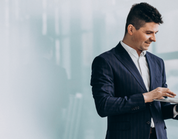 young-handsome-business-man-with-laptop-in-office